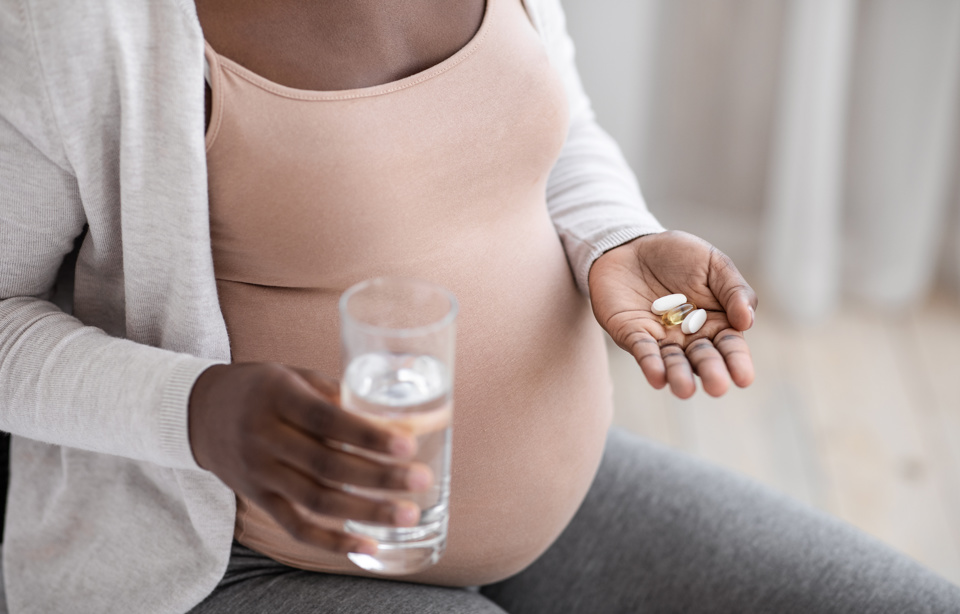Pregnant woman talking pills