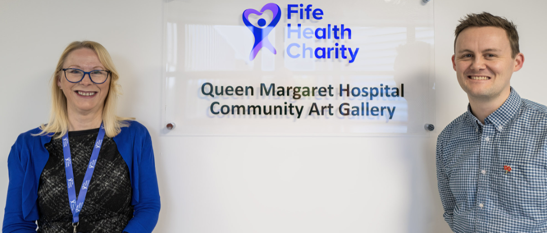 Woman and man beside Fife Health Charity logo and the words "Queen Margaret Hospital Community Art Gallery"