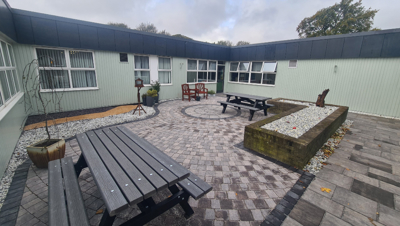 Outdoor courtyard at Glenrothes Hospital - showing picnic benches and seating in a paved area.