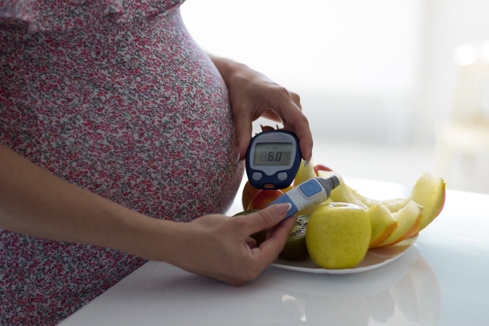 Pregnant woman eating healthily with fruit