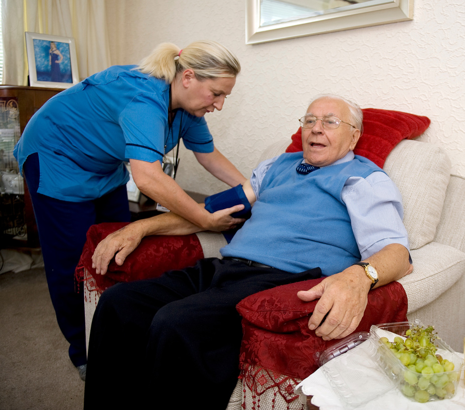 nurse checking older mans blood pressure