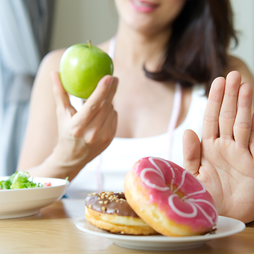 woman turning down donut for an apple instead
