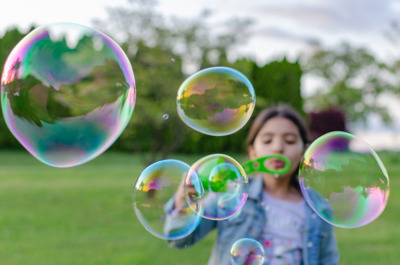 girl blowing big bubbles outdoors