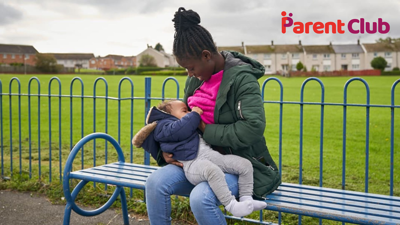 mother breastfeeding baby on park bench