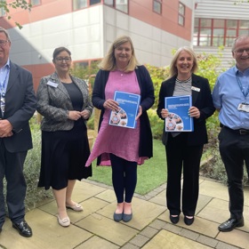 Attendees at the launch of the National Spiritual Care Framework pose with a copy of the document