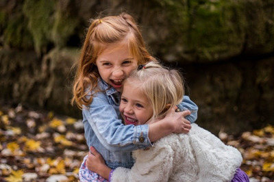 two young girls hugging happy