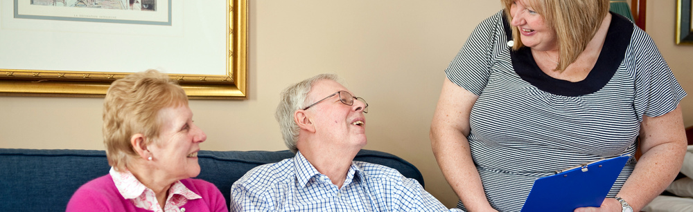 Woman with clipboard speaking to Dementia patient