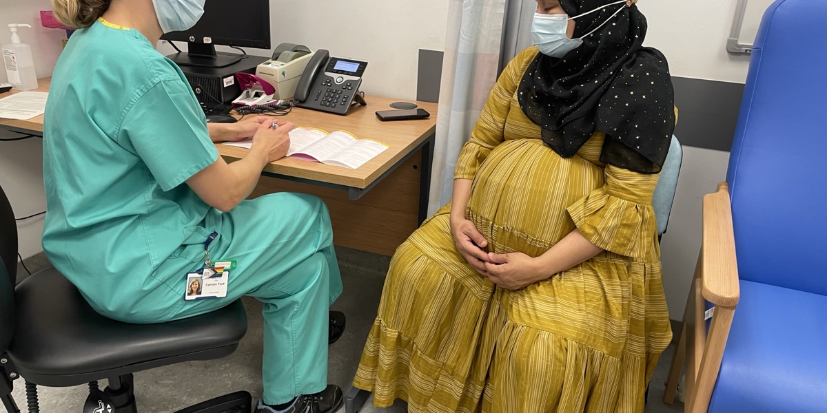 Pregnant woman discussing with doctor