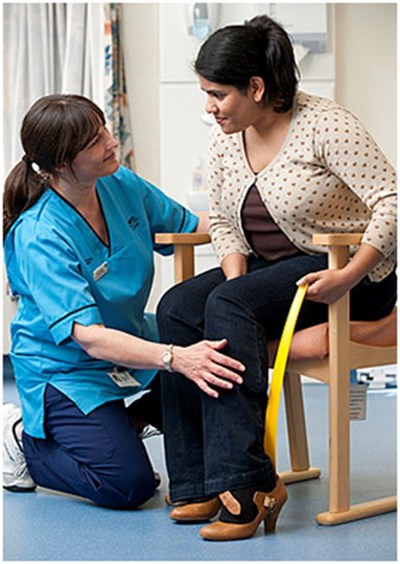 nurse helping patient put on shoe