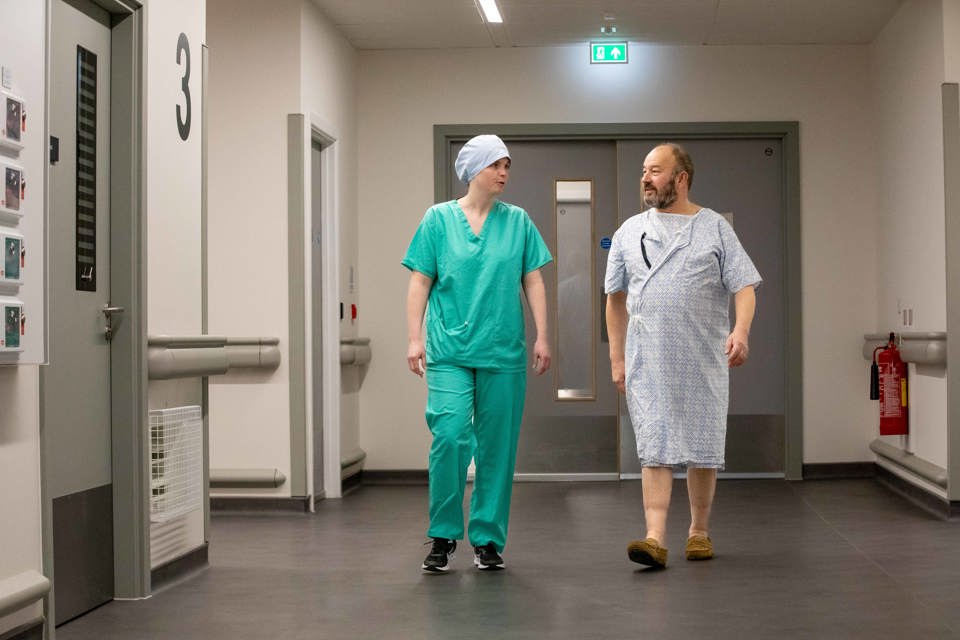 Patient walking to surgery with staff member