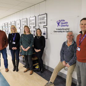 Group In Front Of Charity Logo