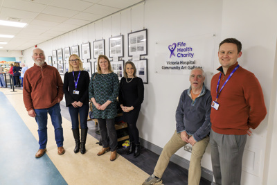 Group In Front Of Charity Logo
