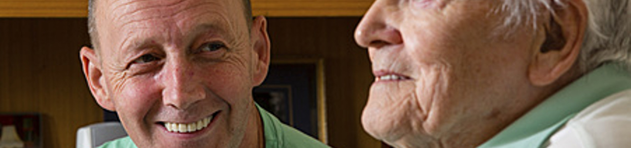 Man smiling looking at older man