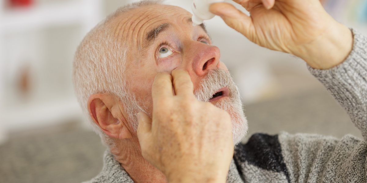 man giving himself eye drops