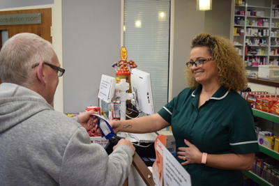 Pharmacist handing over to patient