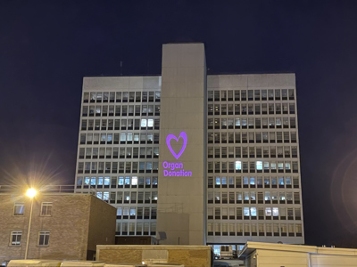 Victoria hospital with projection of pink organ donation logo 