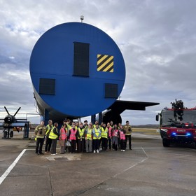 Students outside airplane simulation