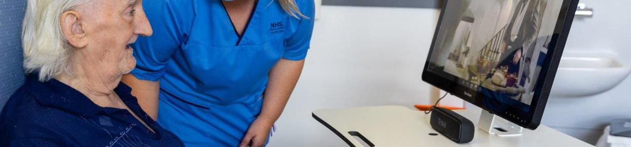 Nurse with an elderly man looking at a screen