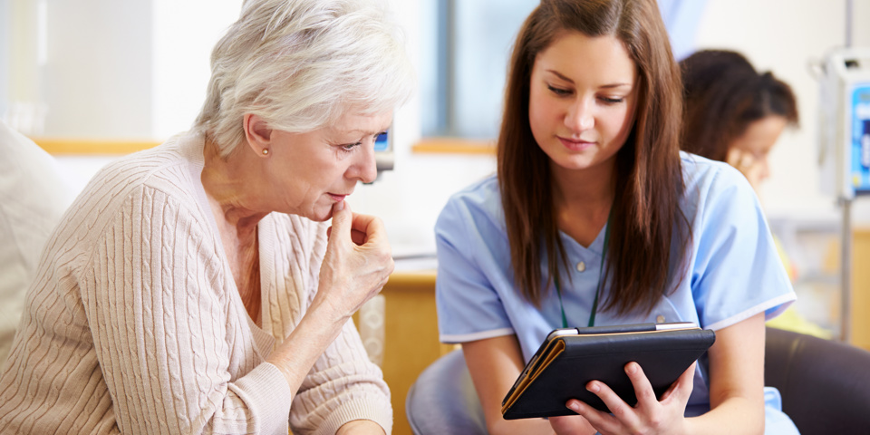 Chemo Patient And Nurse looking at ipad