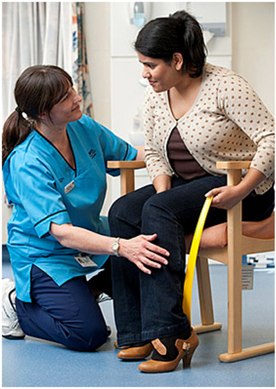 Nurse helping patient put on shoe