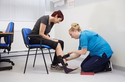 Nurse helping patient with ankle brace