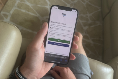 Person holding a mobile phone using the Patient Hub online portal