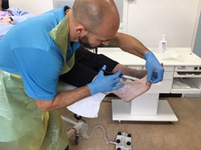 nurse looking at patients nail