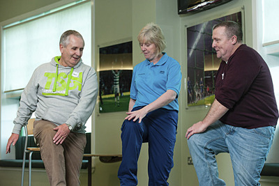 nurse showing patients lifting leg stretch