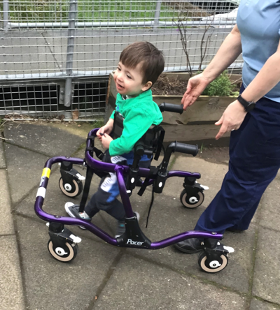young boy in assisted walking frame