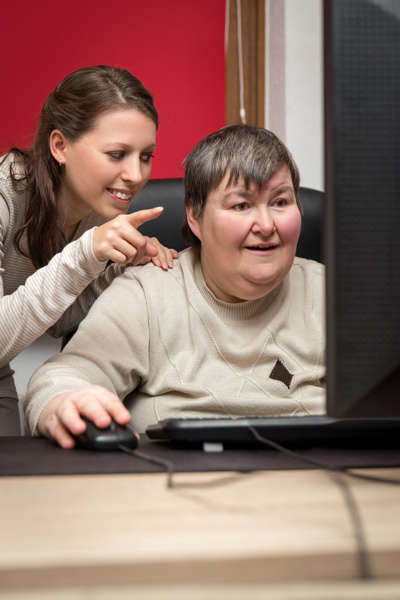 tutor pointing at computer with student